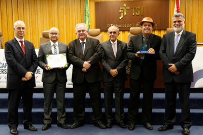 #PraTodosVerem: Imagem mostra seis homens lado a lado, um deles com um diploma nas mãos e outro com um troféu pelo Prêmio que recebeu